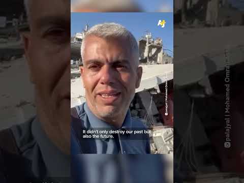 Journalist Mohamed al-Astal speaks in front of the ruins of his home